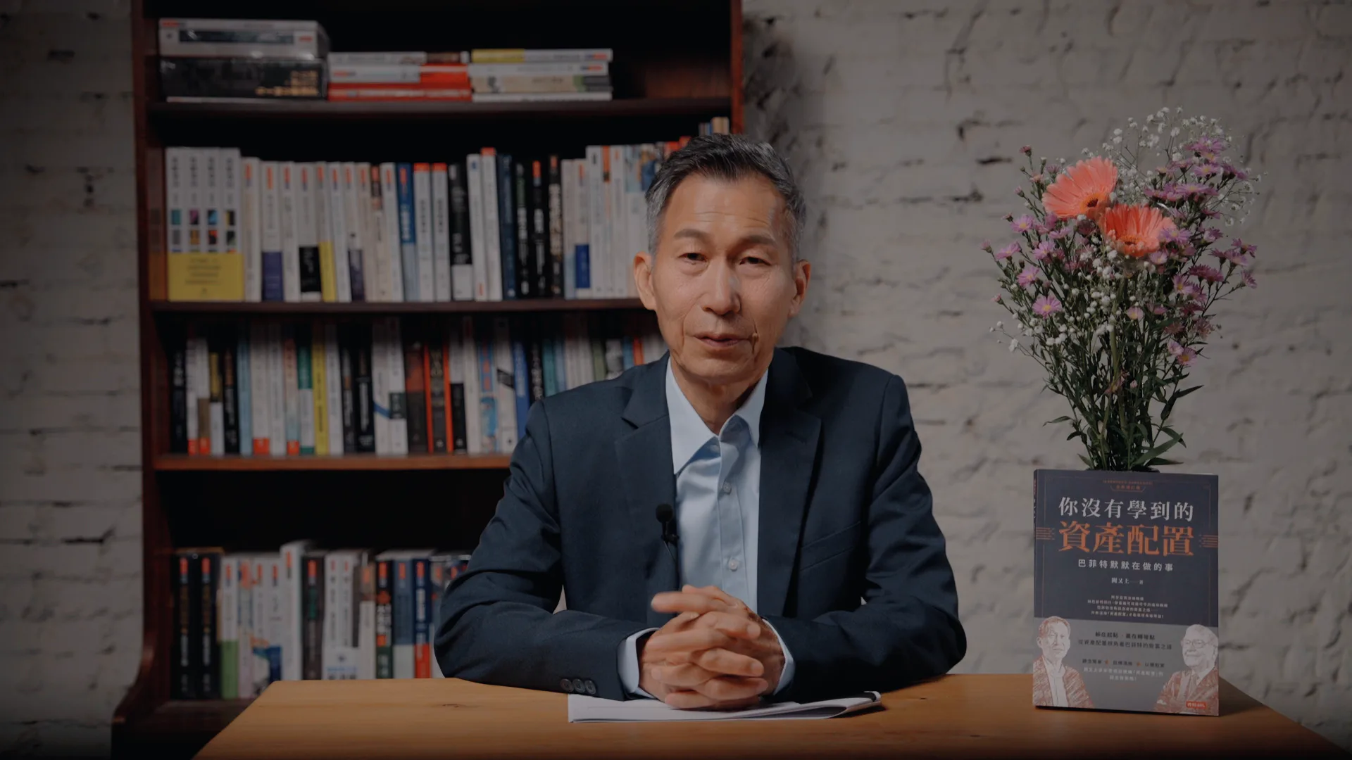 闕又上老師於書房中講授資產配置課程，右側展示課程原書